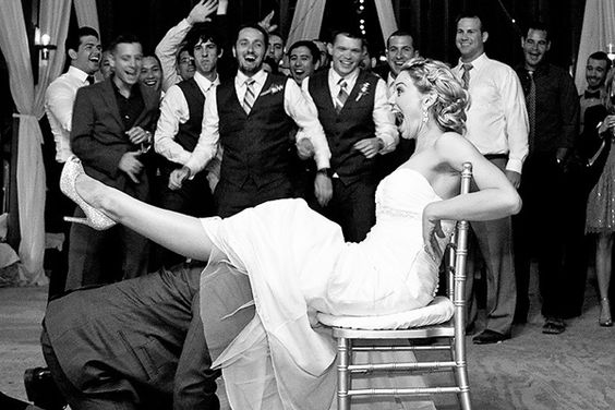 groom taking garter off bride